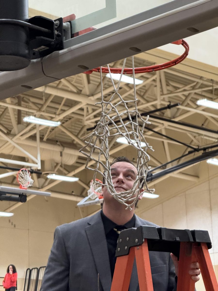 Enochs boys varsity basketball coach Craig Bernardi prepares to make the final cut to save the net after a historic season for the Eagles - who will play in the CIF Sac-Joaquin Division 1 playoffs next week. Enochs won a piece of the CCAL championship for the first time, and this season marked the first since 2009 that Enochs won a league banner for boys basketball. 